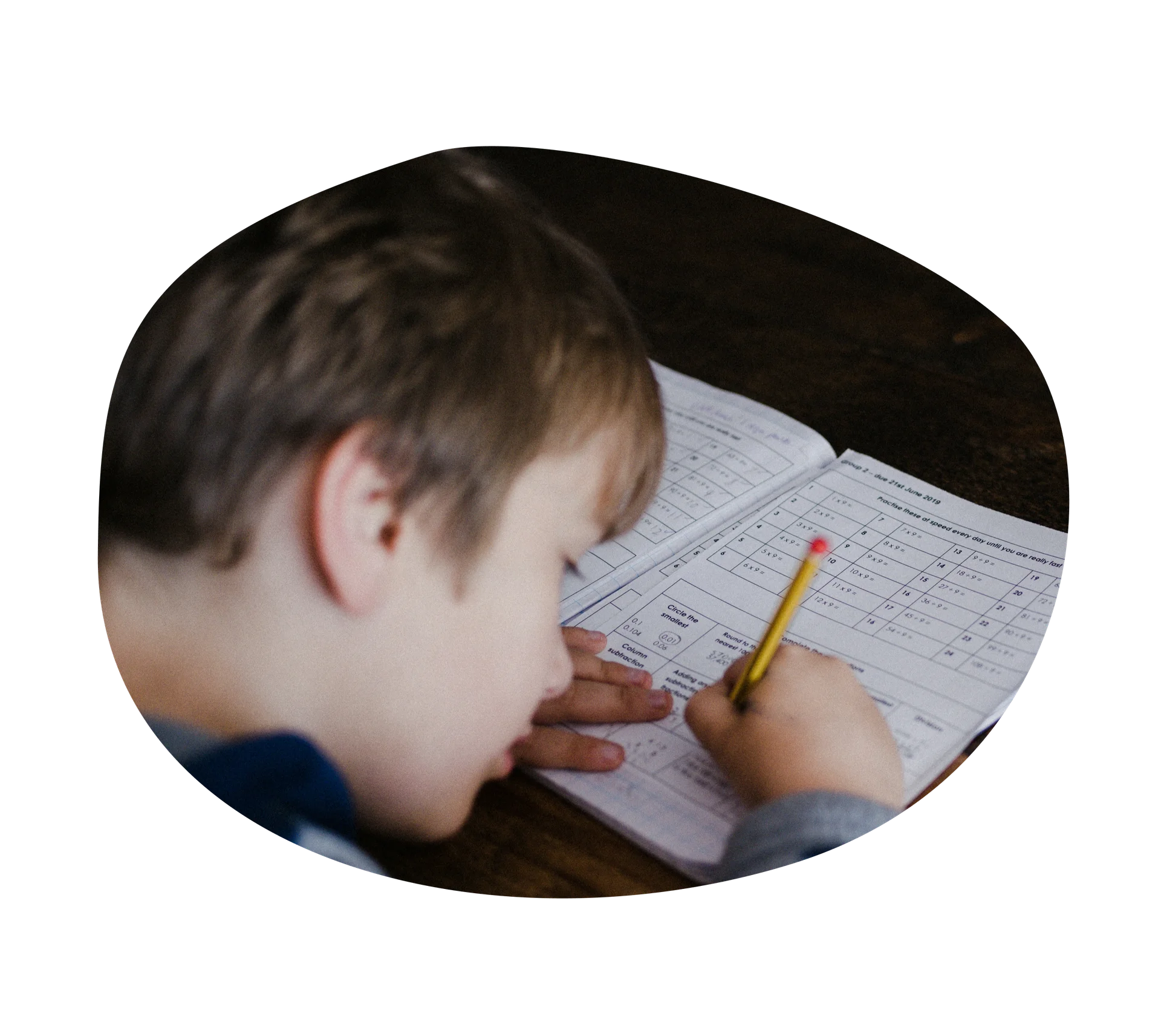 Kid doing homework with a pencil and paper.