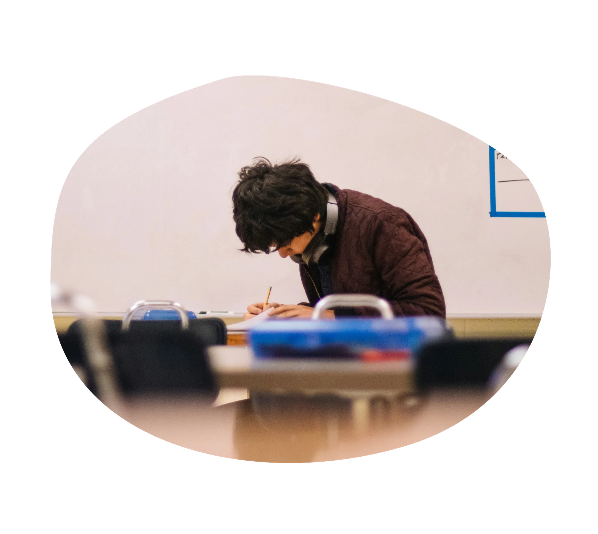 Highschooler sitting at a desk doing homework.
