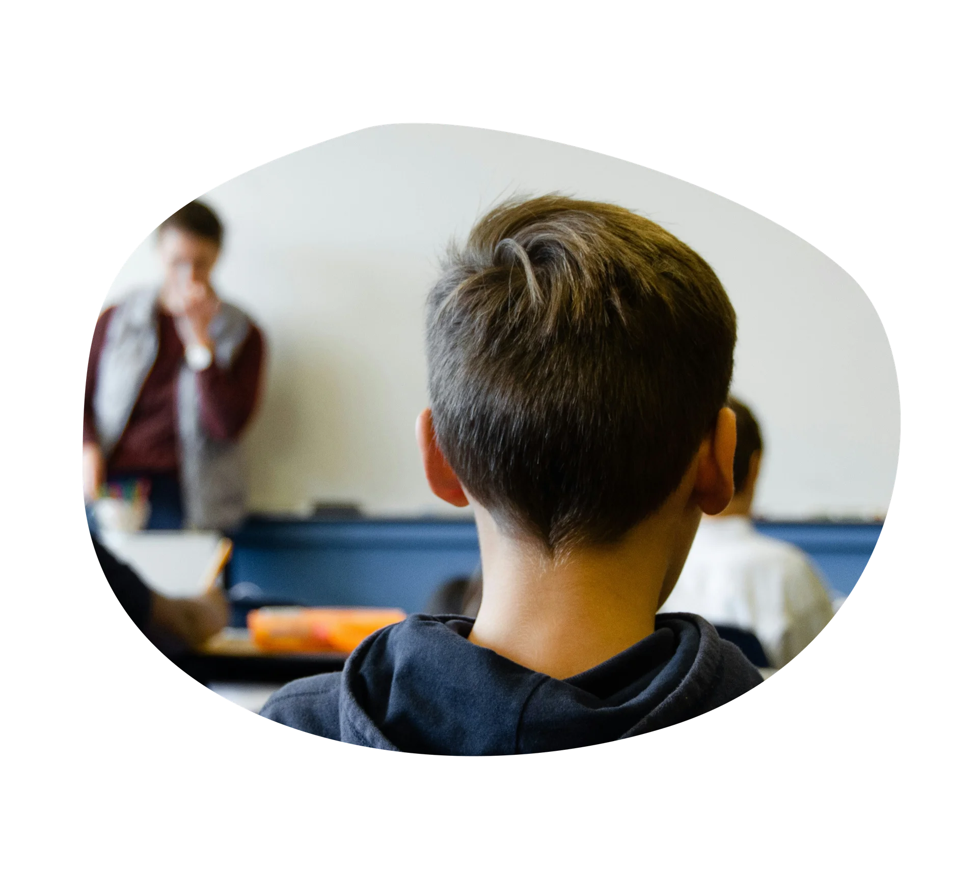 Middle schooler sitting in a classroom with a teacher.